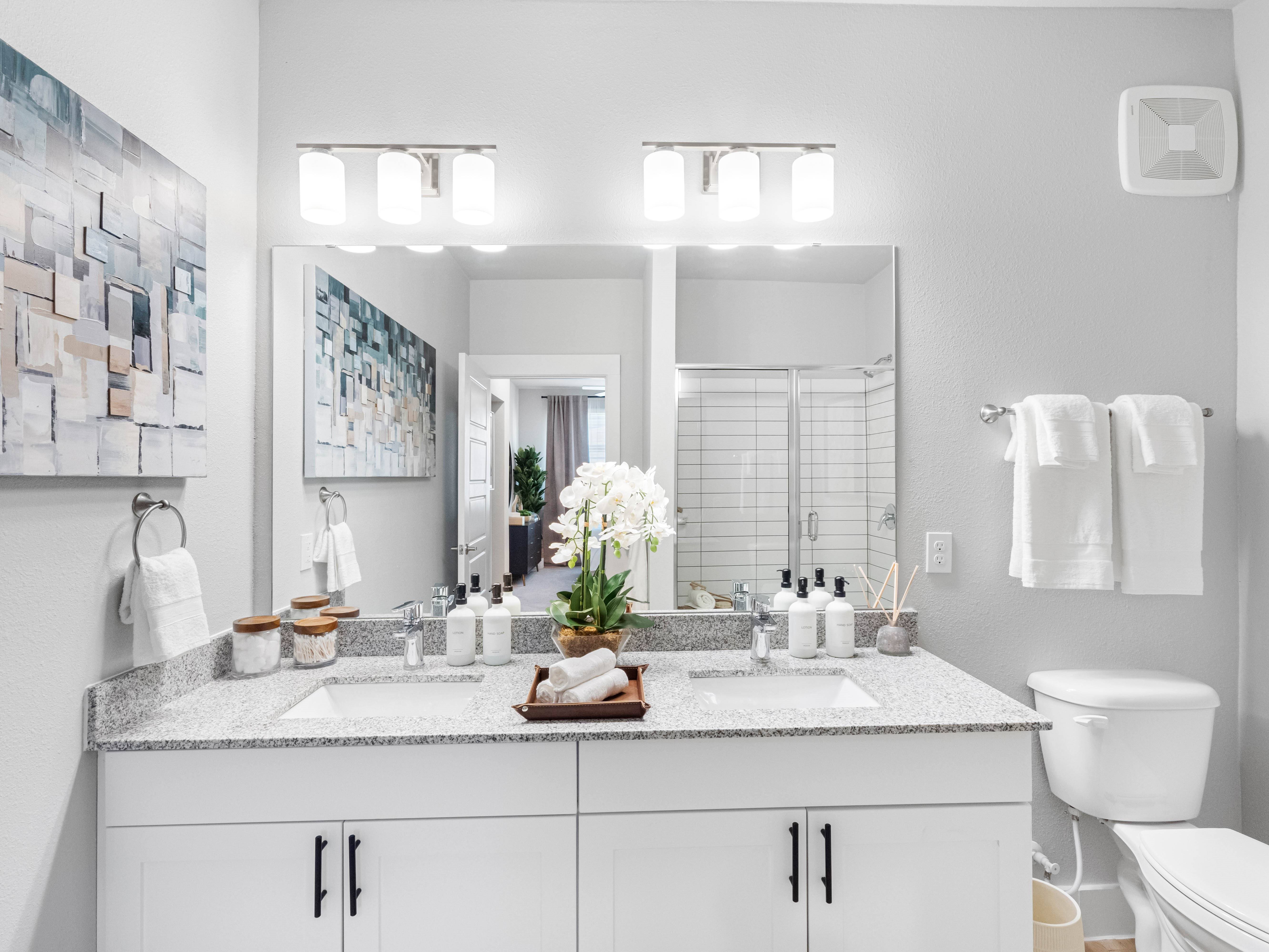 A bathroom with a large mirror above a double sink vanity.